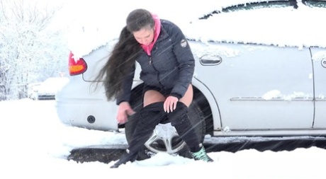 Lara Fox takes a piss beside a parked vehicle during a snowstorm 57666426